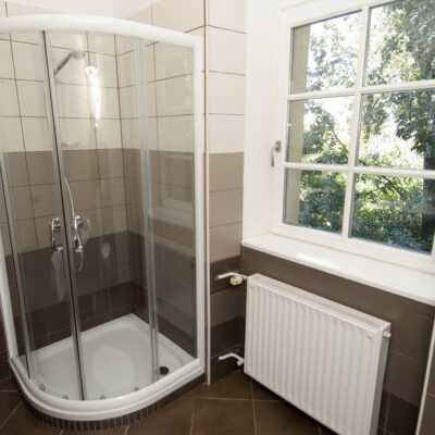 Double Room at Galeria Rooms - A modern shower with a transparent glass door, providing a sleek and elegant look to the bathroom.