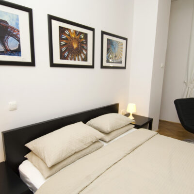 Double Room at Galeria Rooms - a cosy bedroom with a comfortable bed, photographs bove the bed, and a large window.